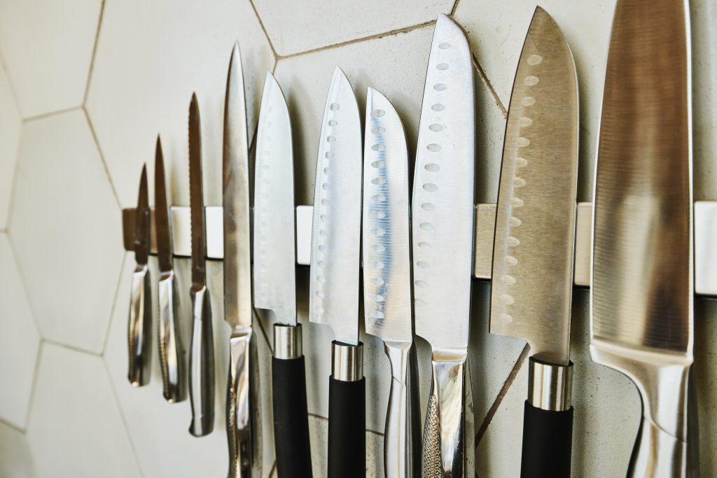Close up shot of kitchen knives on wall in kitchen