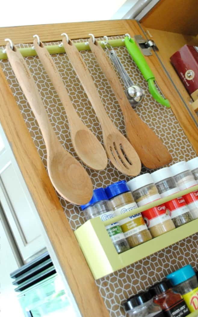 spatulas hanging in the inside of a kitchen cabinet door