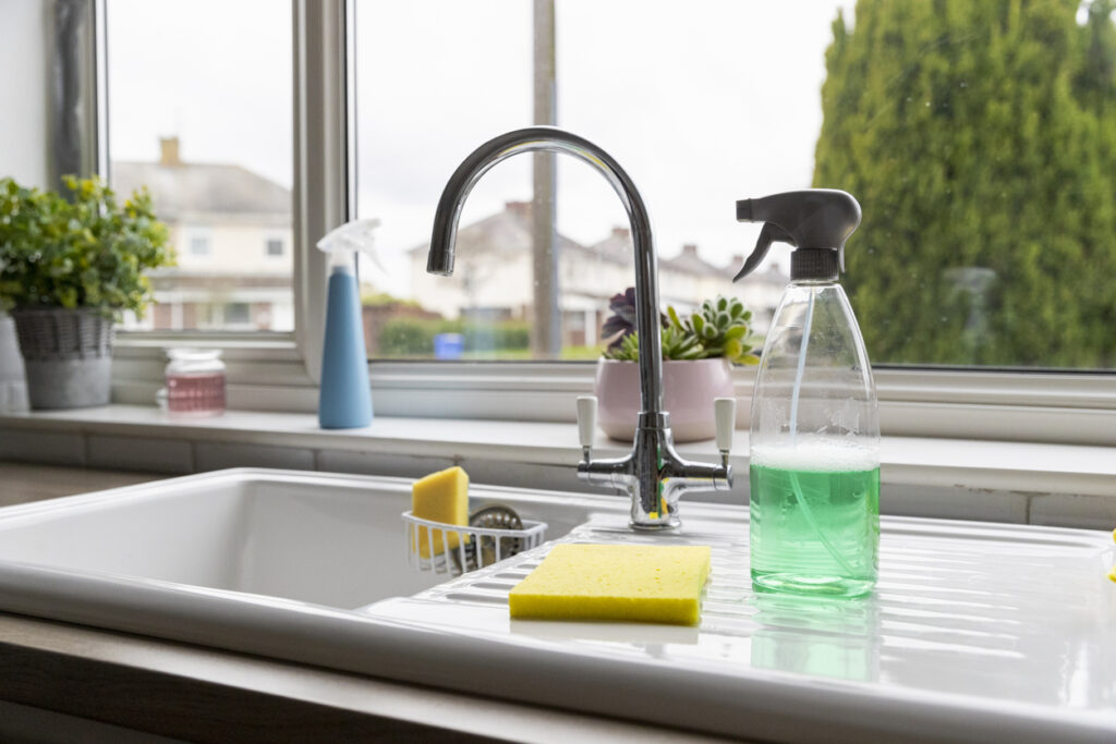 A selection of cleaning products on top of a kitchen sink.